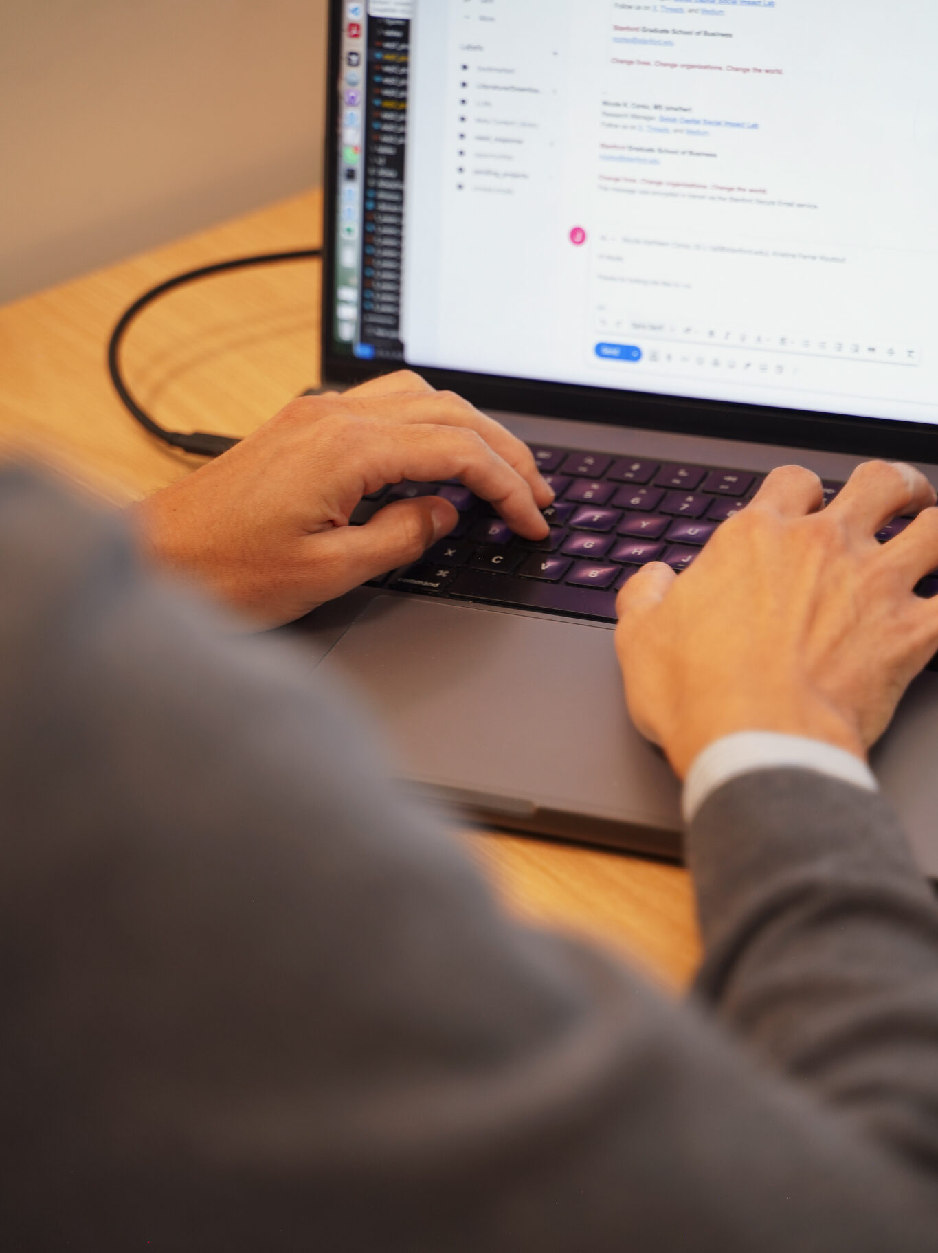 Hands working on a laptop keyboard